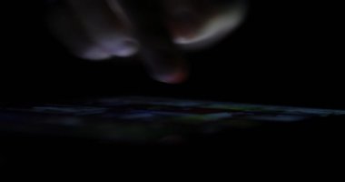 Tatlı bir erkek el dijital tablet geç saatlere kadar üzerinde bir Web sayfası aracılığıyla kaydırma