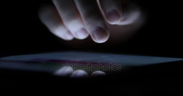 Closeup of a male hand scrolling through a webpage on digital tablet working late — Stock Video