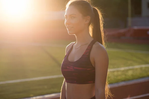 Corredor deportista profesional salir al aire libre al atardecer. Atleta femenina en ropa deportiva en el estadio al aire libre. Actividad deportiva de entrenamiento . — Foto de Stock