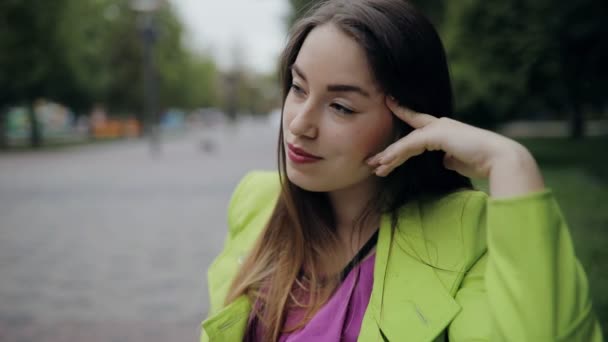 Retrato de mujer bastante coqueta sentada en el banco en el nublado día de verano u otoño — Vídeo de stock