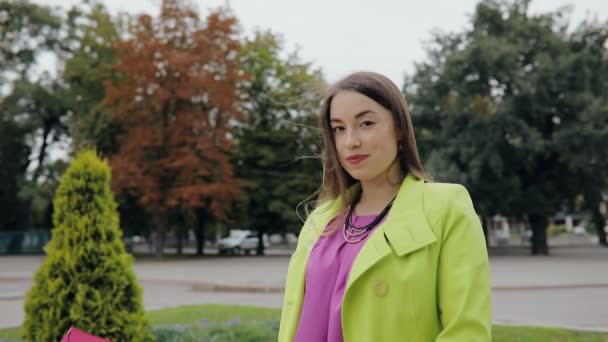 Femme sérieuse sous parapluie rose dans le parc d'automne en plein air — Video