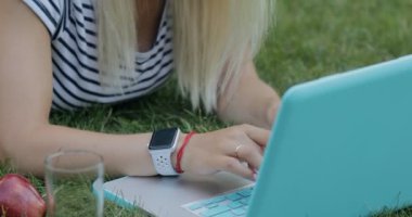 Güzel kadın blogger onu laptop açık park, o suyu içme çimenlerin üzerinde oturan ile çalışma