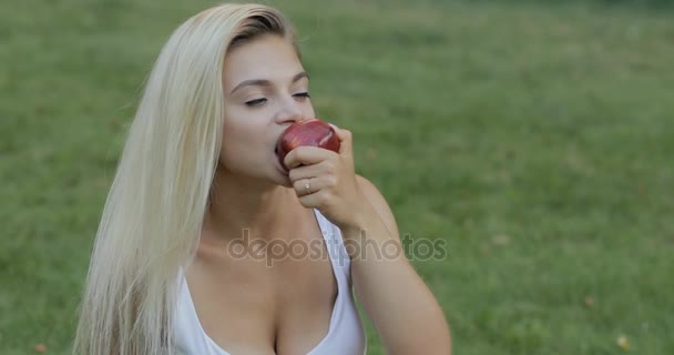 Красива жінка їсть яблуко на відкритому повітрі, здорова їжа — стокове відео