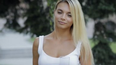 Sağlıklı yaşam tarzı yemek. Gülümseyen komik genç kadın bir elma ayakta açık havada ağır çekimde Park'ta yukarı atar.