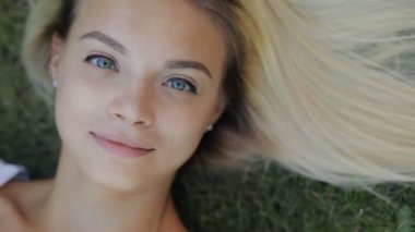 Güzel kadın çekici kız gülmeye bir çim ağır çekimde yatan rahatlatıcı