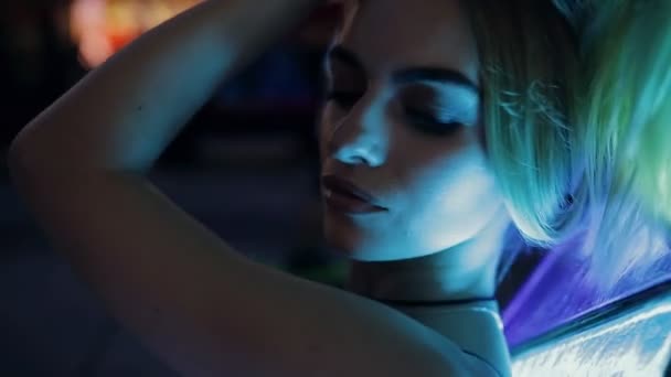 Красива сексуальна жінка в синьому світлі на відкритому повітрі в нічному місті, повільний рух — стокове відео
