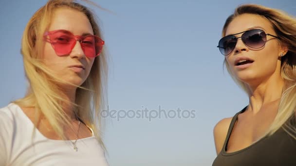 Amigos de meninas sopra em uns brinquedos tubulares em uma praia em férias de verão, câmera lenta — Vídeo de Stock
