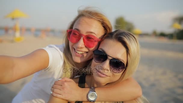 Девушки друзья отдыхают вместе на пляже во время летних каникул, замедленной съемки — стоковое видео