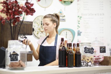 Genç kadın barista kahve onun dükkanında yapıyor.