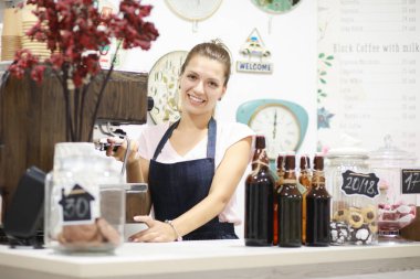 Genç kadın barista kahve onun dükkanında yapıyor.