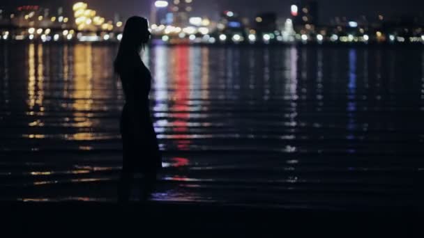 Γυναίκα ψάχνει να στέκεται αστικό τοπίο νύχτα κοντά στον ποταμό — Αρχείο Βίντεο