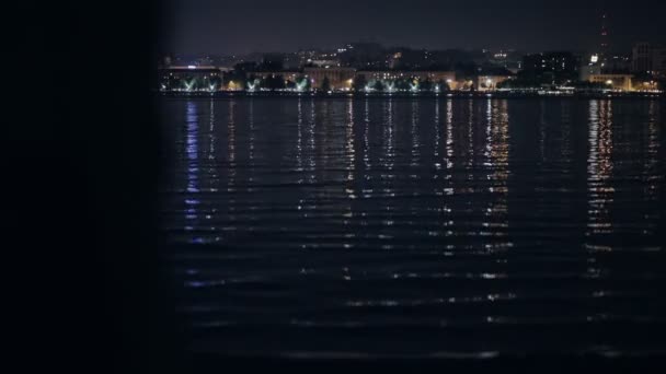 Femme regardant vers le paysage urbain nocturne debout près de la rivière — Video