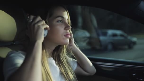 Mujer de lujo escuchar música con auriculares en su coche cómodo, cámara lenta — Vídeo de stock