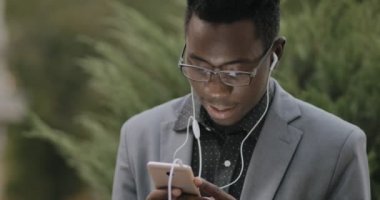 Kulaklıklar açık ile müzik dinlemek Klasik takım elbiseli genç Afrika öğrenci