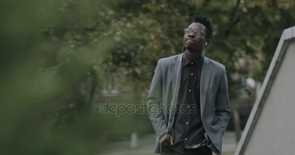Ung afrikansk student i klassisk kostym promenader i city — Stockvideo