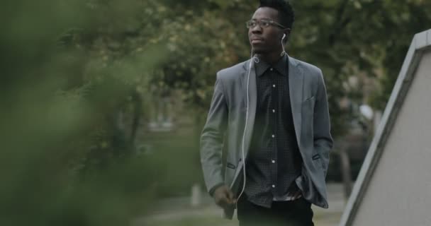 Ung afrikansk student i klassisk kostym promenader i city — Stockvideo