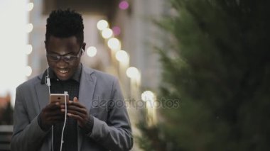 Kulaklıklar açık ile müzik dinlemek Klasik takım elbiseli genç Afrika öğrenci