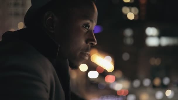 Joven empresario africano mirando a la ciudad nocturna desde Balkony — Vídeo de stock