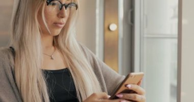 Kadın bir kafede smartphone, cep telefonunuza bakıyordu o kullanma