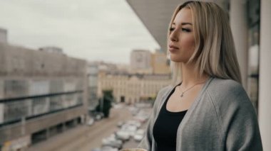 Kadın bir Cafe kahve içmek veya balkonda latte ayakta