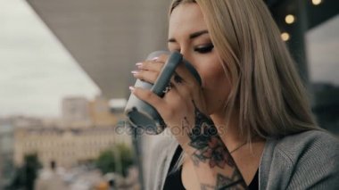 Kadın bir Cafe kahve içmek veya balkonda latte ayakta
