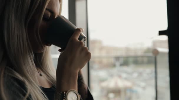 Mujer en un café beber café o café con leche, cámara lenta — Vídeo de stock