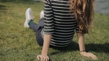 Nehir, çimlerin üzerine oturan mutlu kadın