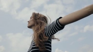 Mutlu kadın gökyüzü arka planda slowmotion açar