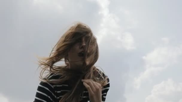 Mulher feliz beija câmera no fundo do céu em câmara lenta — Vídeo de Stock