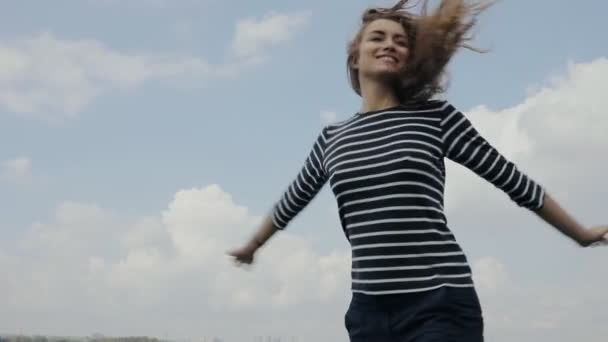 Lycklig kvinna vänder på himmel bakgrund i slowmotion — Stockvideo