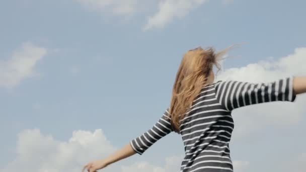 Lycklig kvinna göra antenn kyssar till kameran på himmel bakgrund i slowmotion — Stockvideo