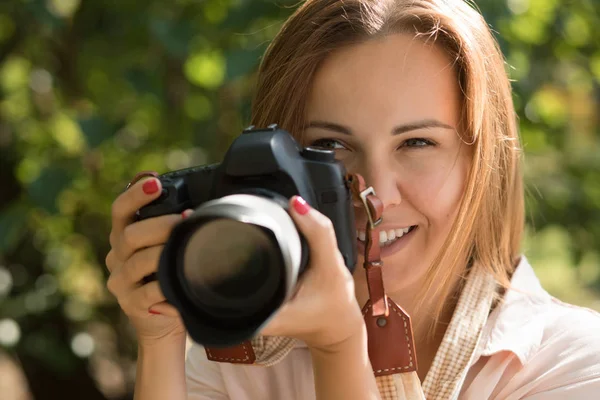 ช่างภาพผู้หญิงถ่ายภาพ ถือกล้องไว้ใกล้หน้าเธอ — ภาพถ่ายสต็อก