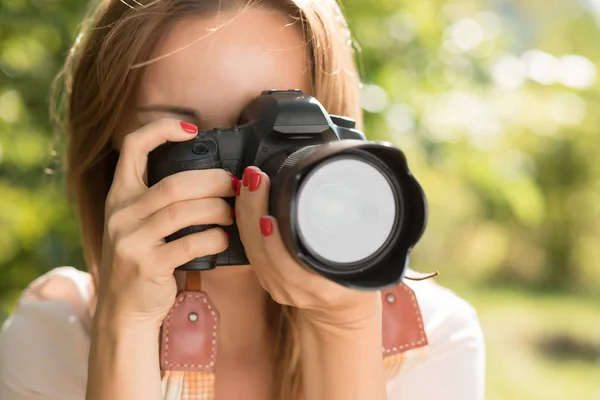 Nainen valokuvaaja tehdä ampua tilalla kamera lähellä hänen kasvonsa — kuvapankkivalokuva