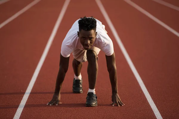 African american male sportsman ready to run on stadium track, sprint run from low start — Stock Photo, Image