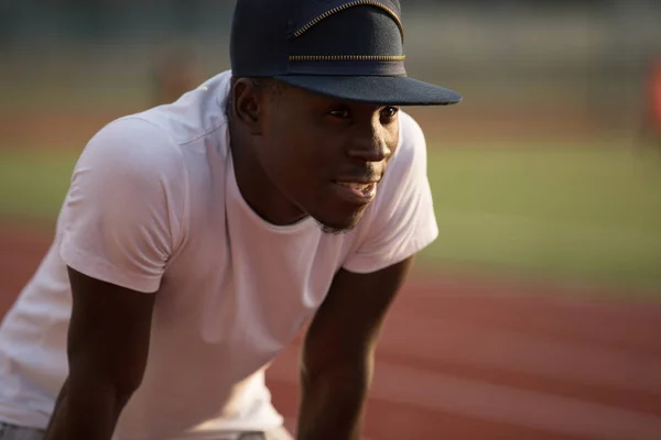 African male sportsman in a cap workout outside, he hardy breathe after running — Stock Photo, Image
