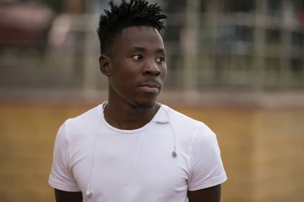 Спортсмен в кепке на стадионе, африканский мужской портрет снаружи — стоковое фото