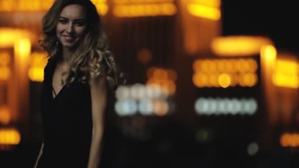 Modella con bei capelli che camminano in una strada di città di notte — Video Stock