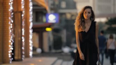 Bir akşam şehir sokak, slowmotion yürüyüş güzel saçlı güzel kadın