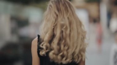 Şehirde yürüyüş güzel saçlı kadın güzel ve fotoğraf makinesi slowmotion çevirir
