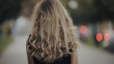 Şehirde yürüyüş güzel saçlı kadın güzel ve fotoğraf makinesi slowmotion çevirir