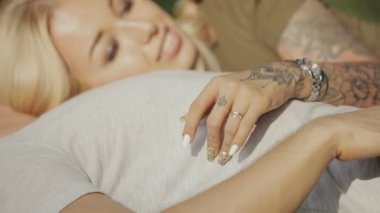 Genç sevgili çift parkta çim üzerinde yalan ve birlikte elele