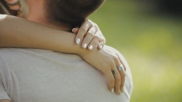 Glückliches junges Paar umarmt sich sitzend auf Gras im Park, Zeitlupe — Stockvideo