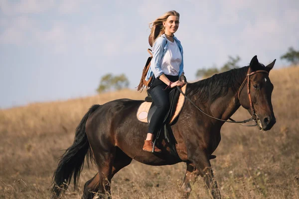 Bela jovem vaqueira equitação ela cavalo no campo — Fotografia de Stock