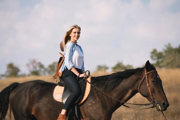 Bela jovem vaqueira equitação ela cavalo no campo — Fotografia de Stock