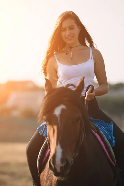 Schöne junge Cowgirl reitet ihr Pferd in Feld — Stockfoto