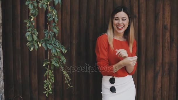 Joven mujer hermosa retrato en gafas de sol cerca de la pared de madera — Vídeos de Stock