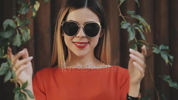Młoda kobieta w pobliżu ściany drewniane przejść między liście winogron — Wideo stockowe