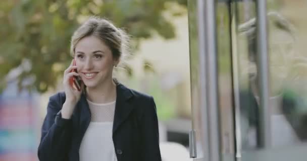 Ung kvinna student i klassisk kostym talar av smart telefon i city — Stockvideo