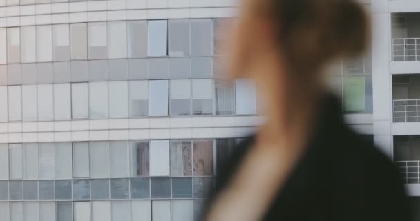 Портрет молодой женщины в классическом костюме поворачивается лицом на балконе высокого этажа — стоковое видео
