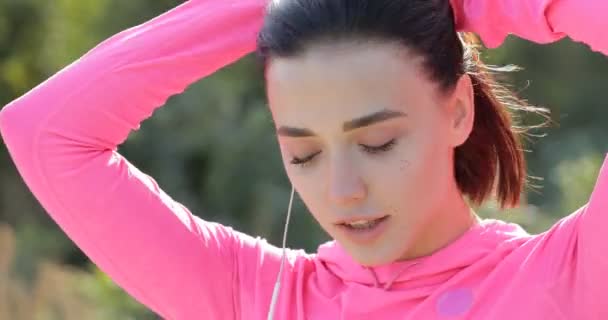 Zblízka s úsměvem sportovkyně vázání vlasy před jogging — Stock video